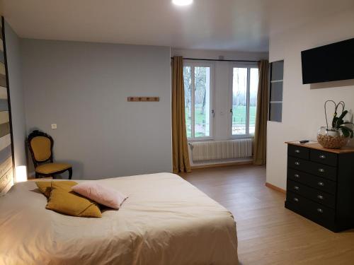 a bedroom with a bed and a dresser and a television at Domaine de Montauban in Perrancey