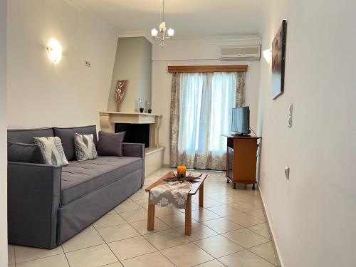 a living room with a gray couch and a table at Ethereal Villas Lefkas in Nydri