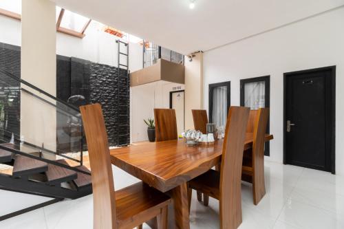 a dining room with a wooden table and chairs at RedDoorz Syariah at Jalan Andalas Padang in Kampungdurian