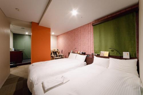 a bedroom with two beds and a green wall at No, 2 Taniji Building - Vacation STAY 91383v in Tokyo