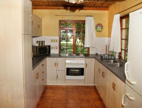 a kitchen with a sink and a stove at Rainbow Glen Self Catering Chalets in Montagu