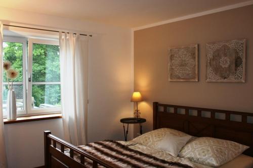 sypialnia z łóżkiem i oknem w obiekcie Ferienwohnung am Herrnberg w mieście Prien am Chiemsee