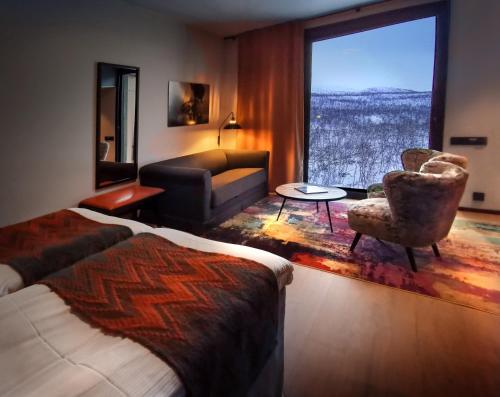 ein Hotelzimmer mit einem Bett, einem Sofa und einem Fenster in der Unterkunft Cahkal Hotel in Kilpisjärvi