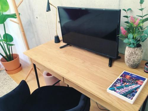 a television sitting on top of a wooden table at Ken's Place四谷 in Tokyo