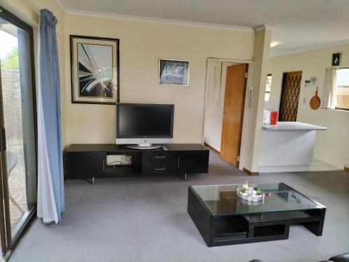 Una sala de estar con televisión y una mesa de café. en 15 on 11th Summerstrand, en Summerstrand