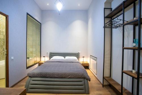 a bedroom with a bed and a blue wall at Nino's Cosy Apartment in Kutaisi