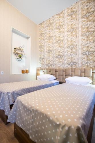 two beds in a room with blue and white sheets at Nino's Cosy Apartment in Kutaisi