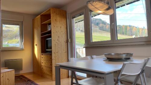 cocina con mesa, sillas y ventanas en Apartment Katrca Kranjska Gora en Kranjska Gora