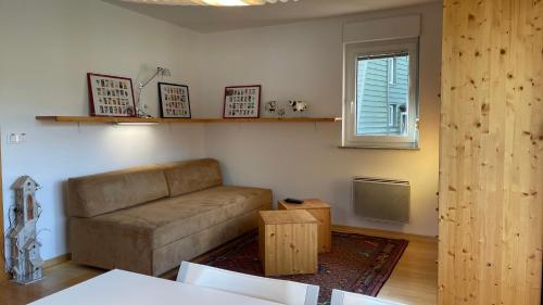 un soggiorno con divano e finestra di Apartment Katrca Kranjska Gora a Kranjska Gora