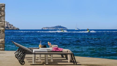 a woman sitting on a picnic table on the beach at Hotel Splendid in Dubrovnik