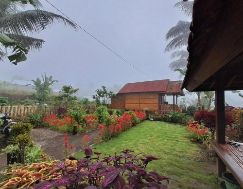 a garden with colorful flowers and a building at Kurni's Cabin in Sapit