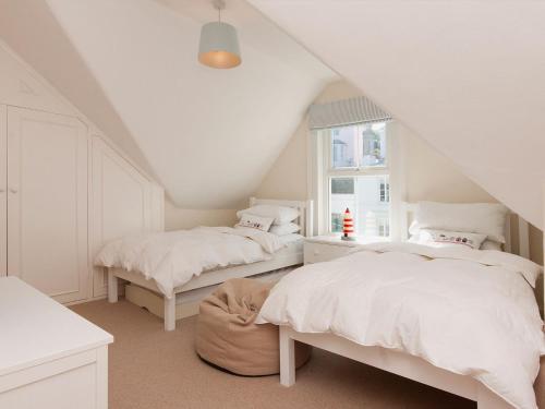 a bedroom with two beds and a window at Estuary View in Salcombe