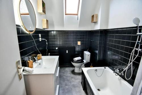 a bathroom with two sinks and a tub and a toilet at Aux Toits d'Alsace in Sélestat