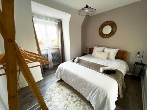 a bedroom with a large bed and a mirror at Aux Toits d'Alsace in Sélestat