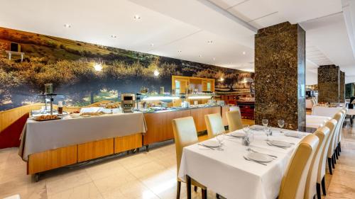 un ristorante con tavoli e sedie bianchi e un bar di Hotel Splendid a Dubrovnik