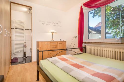 Schlafzimmer mit einem Bett und einem Fenster in der Unterkunft Ferienwohnung Sonnenschein in Langenargen