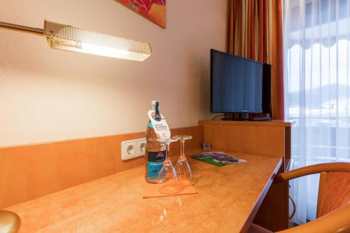 a room with a table with a bottle and two glasses at BSW Schwarzwaldhotel Baiersbronn in Baiersbronn