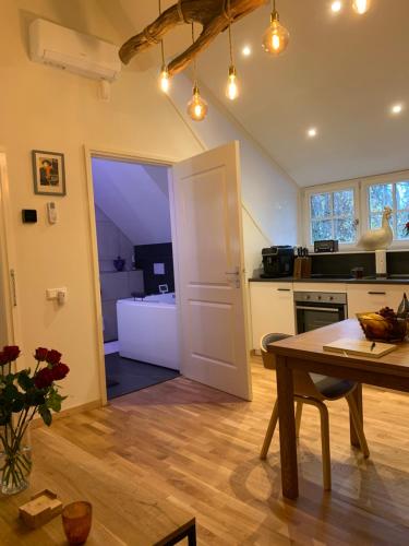 una cucina con tavolo e una sala da pranzo di Bed and Breakfast De Haen - Privé-appartementen van 43 of 60 m2 met tweepersoons bubbelbad - Finse sauna - in westvleugel van luxe villa a Oss