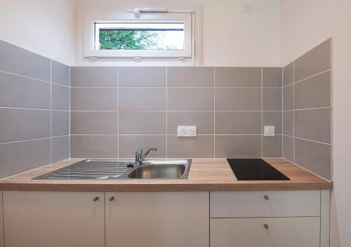 uma cozinha com um lavatório e uma janela em Aux Portes des Monts d'Aubrac em Espalion