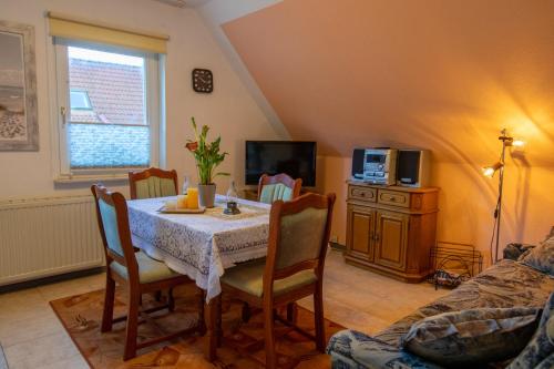 a dining room with a table and chairs and a tv at Haus Parchow in Baabe