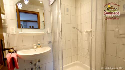 a bathroom with a shower and a sink and a shower at Hotel-Gasthof-Sonneck in Reit im Winkl