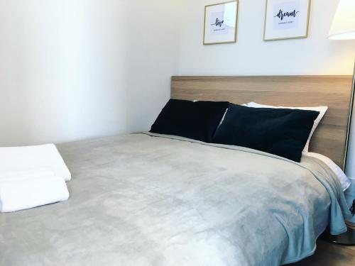 a bedroom with a large bed with black pillows at Ken's Place四谷 in Tokyo