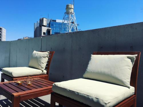 a pair of chairs and a table on a balcony at Ken's Place四谷 in Tokyo
