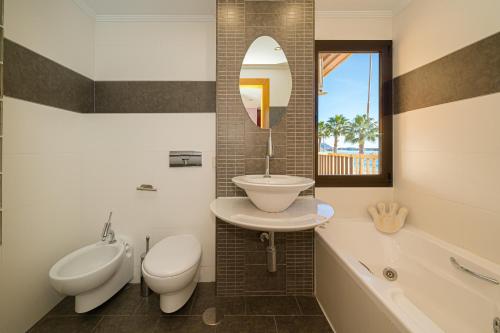 a bathroom with a sink and a toilet and a tub at Apto Villajoyosa 1ª línea in Villajoyosa