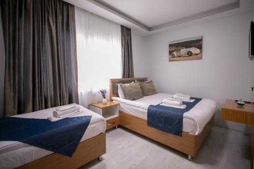 a hotel room with two beds and a window at Güven House İstanbul in Istanbul