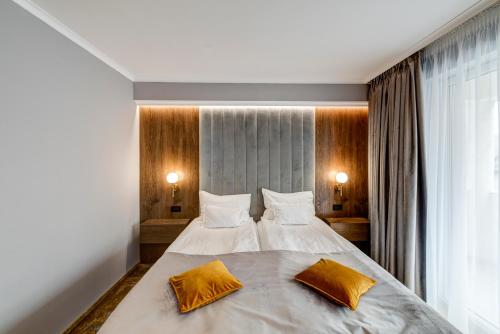 a bedroom with a large bed with two pillows on it at Pensiunea Montana Popa in Blaj