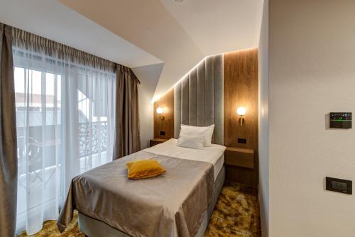 a hotel room with a bed and a large window at Pensiunea Montana Popa in Blaj