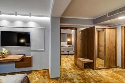 a hotel room with a television and a bedroom at Pensiunea Montana Popa in Blaj