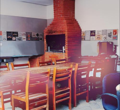 a dining room with a table and chairs and a fireplace at Royal-inn SPA & Pousada in Itanhaém