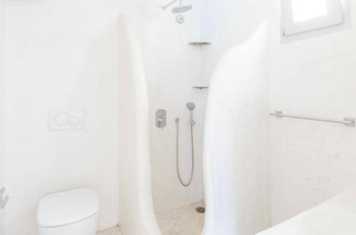 a white bathroom with a shower and a toilet at Villa Maestro Mykonos in Agios Ioannis Mykonos