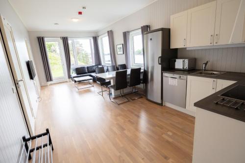 eine Küche und ein Wohnzimmer mit einem Tisch und Stühlen in der Unterkunft Kristiansand Feriesenter in Kristiansand