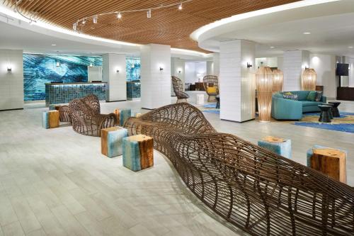 un hall avec des chaises et des tables en osier dans un bâtiment dans l'établissement OUTRIGGER Waikiki Beachcomber Hotel, à Honolulu