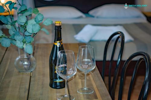 a bottle of champagne and two wine glasses on a table at Ostia Holiday Naxos in Lido di Ostia