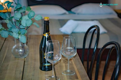 a bottle of champagne and two wine glasses on a table at Casa Vacanze Naxos in Lido di Ostia