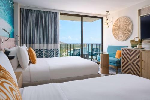 um quarto de hotel com duas camas e uma varanda em OUTRIGGER Waikiki Beachcomber Hotel em Honolulu