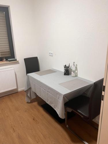 a table with two chairs and a white table cloth on it at Monteurunterkunft Heger - Beste Verkehrsanbindung in Aalen