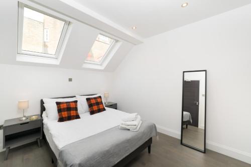 a white bedroom with a bed and a mirror at Oxford Street 2 Bedr, 3 Beds, 2,5 Bath, 2 min subway in London
