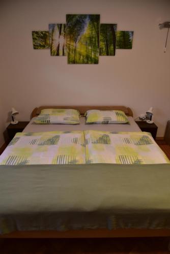 a bed in a bedroom with posters on the wall at Primula Apartment in Blejska Dobrava