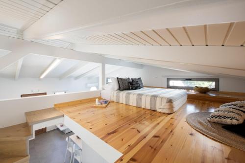 ein Wohnzimmer mit einem Bett und Holzboden in der Unterkunft Theros Residence in Hersonissos