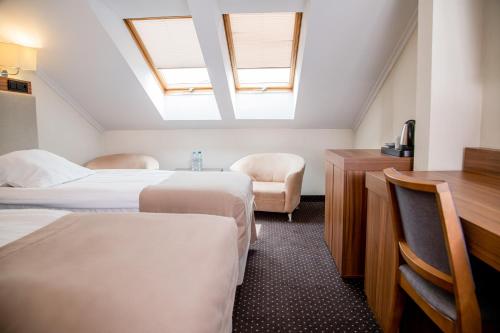 Pokój hotelowy z 2 łóżkami i biurkiem w obiekcie Hotel Villa Verde Congress & Spa w mieście Zawiercie Nowe