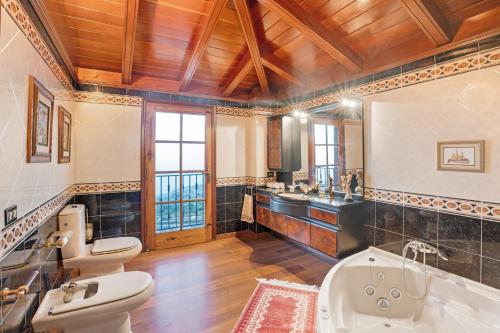 a bathroom with two toilets and a tub and a sink at Casa La Victoria in La Victoria de Acentejo