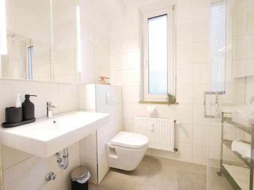 uma casa de banho branca com um WC e um lavatório em 75 m2, zentral, gemütlich, eigener Parkplatz em Osnabrück