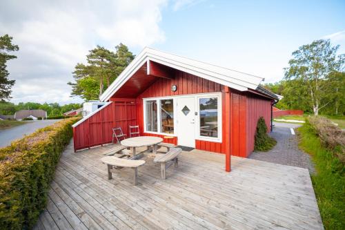 a red building with a table and chairs on a deck at Kristiansand Feriesenter in Kristiansand