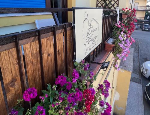 a balcony with flowers and a sign for a boutique at Donna Viruzza in Schiavonea