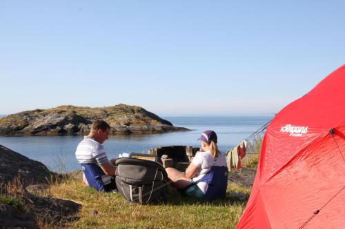 a man and a woman sitting next to a tent at Kristiansand Feriesenter in Kristiansand