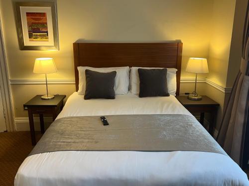 فندق كافنديش في لندن: غرفة نوم بسرير كبير فيها مصباحين